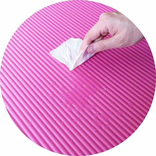 Hand veegt roze yogamat schoon