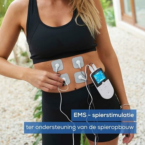 Vrouw gebruikt EMS-spierstimulatieapparaat op buik